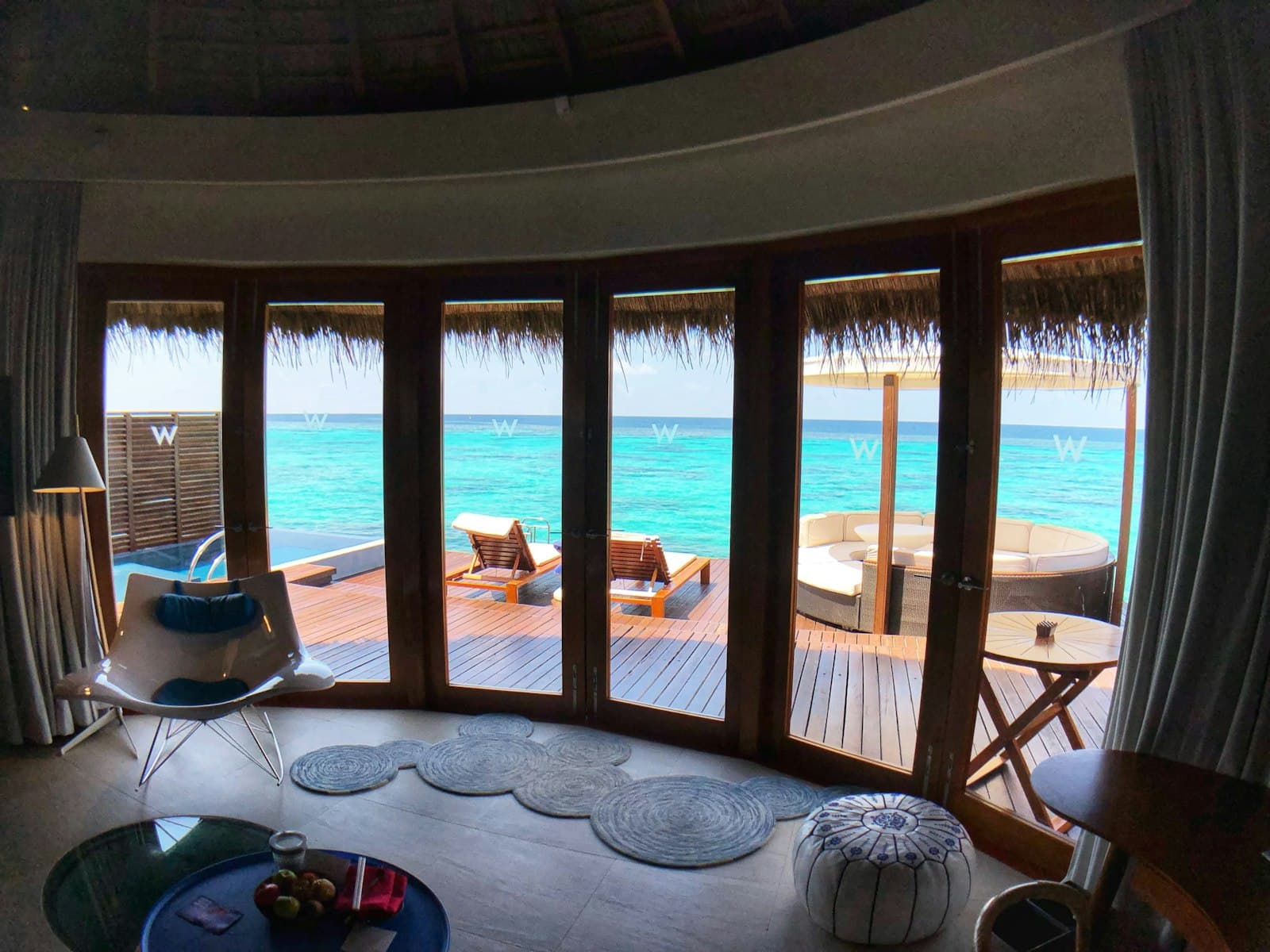 A villa interior looking out over water at first light